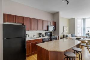 a kitchen with a black refrigerator and wooden cabinets at Loop 1br w gym doorman nr L Grant Park CHI-812 in Chicago