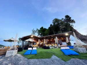 un complejo con sillas azules y blancas y un edificio en 7 Heaven camping Lanta en Krabi