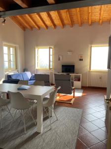 een woonkamer met een tafel en stoelen en een bank bij Appartamento Cristol in Gargnano