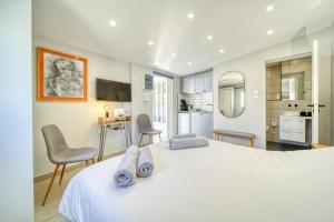 een slaapkamer met een groot wit bed en een keuken bij Chic rooftop studio w/ terrace - Near Acropolis in Athene