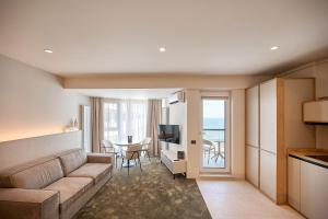 uma sala de estar com um sofá e uma mesa em Alezzi Infinity Aparthotel & Spa em Mamaia Nord – Năvodari