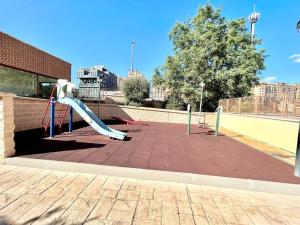 un parque infantil con tobogán en un aparcamiento en Valleca Tren Sierra Guadalupe 1, en Madrid