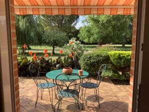 un patio con mesa y sillas y un jardín en Gîte T1 bis,40 m2, en Molières