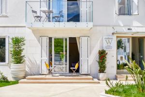 a white house with two chairs and a balcony at MAISON W in Kotor