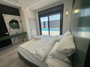 um quarto com uma cama e vista para uma piscina em  alzain 2 villas فلل الزين ٢ em Jericó