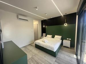 1 dormitorio con cama y pared verde en  alzain 2 villas فلل الزين ٢ en Jericho