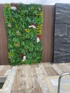uma parede verde com flores e plantas sobre ela em  alzain 2 villas فلل الزين ٢ em Jericó