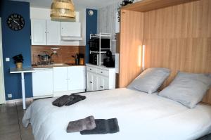 a bedroom with a bed with two towels on it at Le Petit Matelot, studio fonctionnel avec loggia in Courseulles-sur-Mer