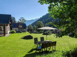 a table and two chairs and an umbrella in a yard at Ferienwohnung Ingrid in Radmer an der Hasel