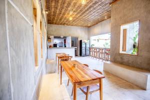Pokój z 2 drewnianymi stołami i kuchnią w obiekcie Pachamama Canggu Bali w mieście Canggu