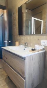 uma casa de banho com um lavatório branco e um espelho. em Casa Monte Zebio em Asiago