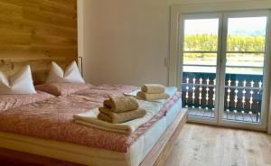 1 dormitorio con 1 cama con toallas en Seegut Steeg am Hallstättersee en Bad Goisern