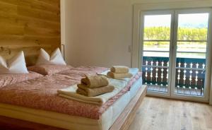 a bedroom with a bed with towels on it at Seegut Steeg am Hallstättersee in Bad Goisern