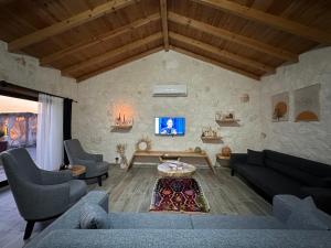 uma sala de estar com um sofá, cadeiras e uma mesa em Villa Luvia em Kas