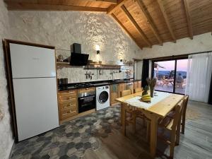 een keuken met een tafel en een witte koelkast bij Villa Luvia in Kas