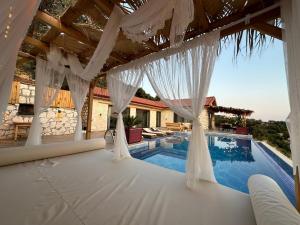 uma casa com uma piscina com cortinas brancas em Villa Luvia em Kas
