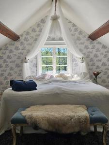 Schlafzimmer mit einem großen Bett und einem Fenster in der Unterkunft Mysigt 1720 tals torp på privat halvö nära Göteborg in Mölnlycke