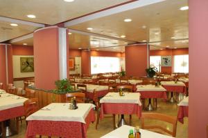 restauracja ze stołami i krzesłami w pokoju w obiekcie Hotel Ezzelino w mieście San Zenone