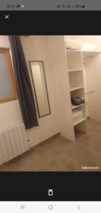 uma foto de uma sala com um espelho e uma cortina em Jolie T2 en rez de chaussée em Carcassonne