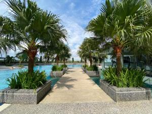 a swimming pool with palm trees in a resort at The Platino By Antlerzone in Johor Bahru