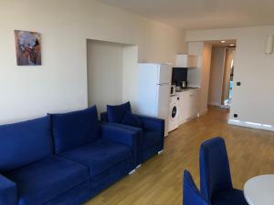 Il comprend un salon avec un canapé bleu et une cuisine. dans l'établissement Dream Orbi City in Batumi, à Batoumi