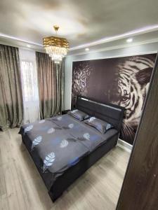 sypialnia z łóżkiem z dużym obrazem na ścianie w obiekcie kvartira_apartment w mieście Ałma-Ata