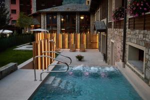 a swimming pool in a yard next to a building at Blu Hotel Acquaseria in Ponte di Legno