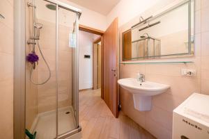un bagno con doccia in vetro e lavandino di ApartmentsGarda - Corte Sant'Andrea a Lazise Altre 39 foto