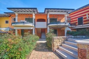 un edificio con balconi e scale di fronte ad esso di ApartmentsGarda - Corte Sant'Andrea a Lazise