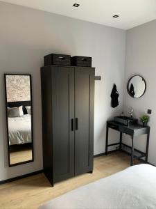 1 dormitorio con 1 cama, armario y espejo en loftlivinq@sea, en Middelkerke