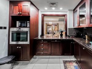 a kitchen with wooden cabinets and a counter top at Trophy - Burj Khalifa View Serenity Suite in Dubai