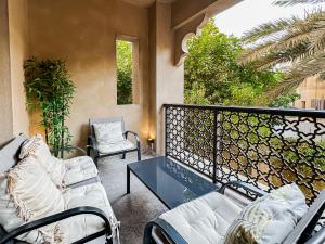 - un balcon avec un canapé, une table et des chaises dans l'établissement Trophy - Burj Khalifa View Serenity Suite, à Dubaï