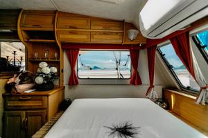 a bedroom with a bed and a window in a boat at 7 Heaven camping Lanta in Krabi town