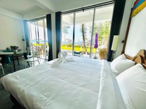Una cama blanca grande en una habitación con una ventana grande. en 7 Heaven camping Lanta, en Krabi 17 fotos más