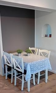 a white dining room table with chairs and a blue table cloth at Apartment by the fjord in Storekra