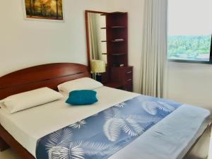 a bedroom with a bed with a blue and white blanket at Oceanfront Condos Galle-Apartment L410 A in Galle