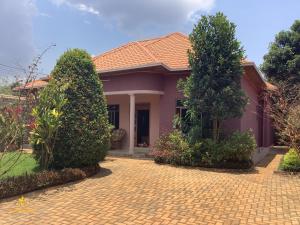 a house with two trees and a brick driveway at Pleasant Rusororo in Kigali