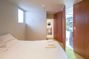 Akizuki OKO art&inn في Asakura: غرفة نوم بسرير ابيض ونافذة