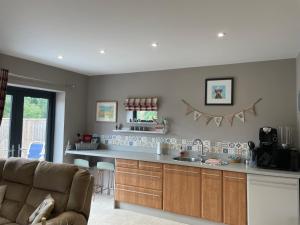 a kitchen with a couch and a counter top at The Paddocks - Spacious annexe with rural outlook. in Wareham