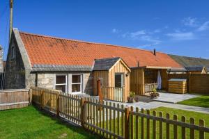 una valla de madera frente a una casa en Country Cottage by St. Andrews en St Andrews