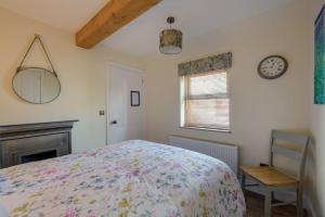 a bedroom with a bed and a clock on the wall at Country Cottage by St. Andrews in St Andrews