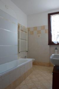 a bathroom with a bath tub and a sink at Bella Ciao Airport Apartment in Seriate