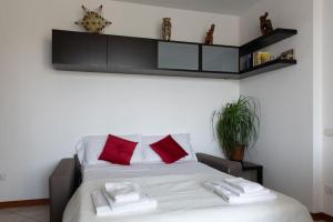 a bedroom with a bed with two red pillows at Bella Ciao Airport Apartment in Seriate