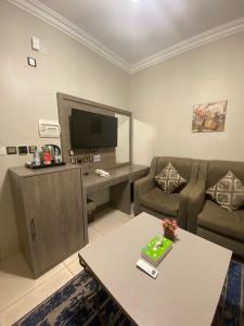 a living room with a couch and a tv at فندق اجنحة السمو بجازان in Jazan