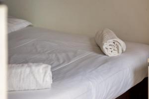 - un lit blanc avec des draps blancs et des serviettes dans l'établissement Le BlueArt, votre logement au cœur de Rouen, à Rouen