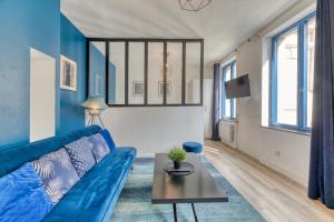 - un salon avec un canapé bleu et une table dans l'établissement Le BlueArt, votre logement au cœur de Rouen, à Rouen