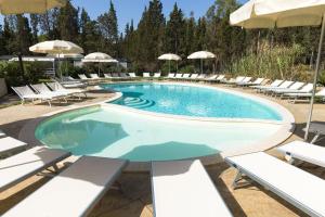 a swimming pool with chairs and umbrellas at Camping Village Flumendosa in Santa Margherita di Pula