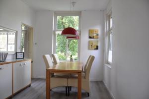 een keuken en eetkamer met een houten tafel en stoelen bij Het Voorhuis in Grolloo