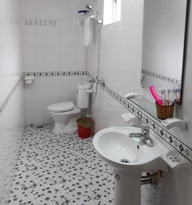 a white bathroom with a sink and a toilet at TD Luxury Hotel in Cat Ba