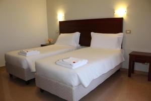 2 letti in camera d'albergo con asciugamani di Città Della Notte ad Augusta